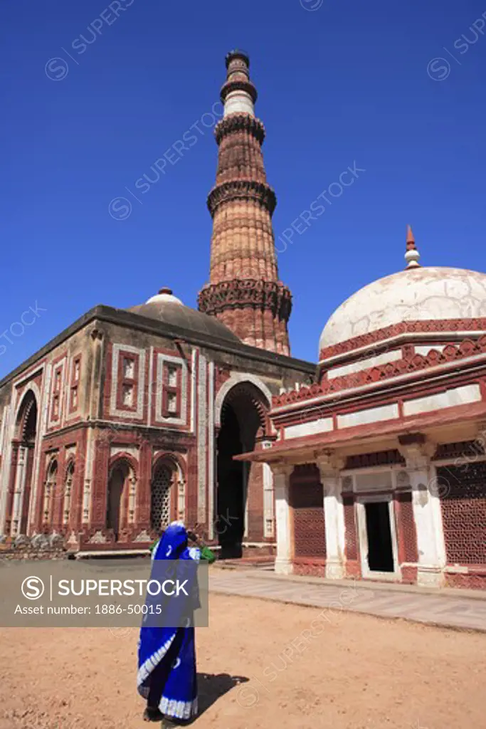 Woman watching Alai Darwaza Imam Zamin's tomb and Qutab Minar built in 1311 red sandstone tower ; Indo-Muslim art ; Delhi sultanate ; Delhi ; India UNESCO World Heritage Site