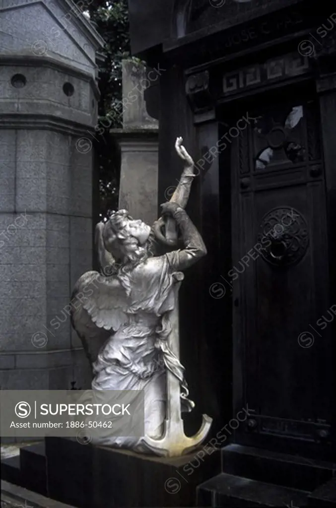 MARBLE ANGEL decorates a tomb at the CEMETERIO DE LA RECOLETA (RECOLETA CEMETERY) - BUENOS AIRES, ARGENTINA
