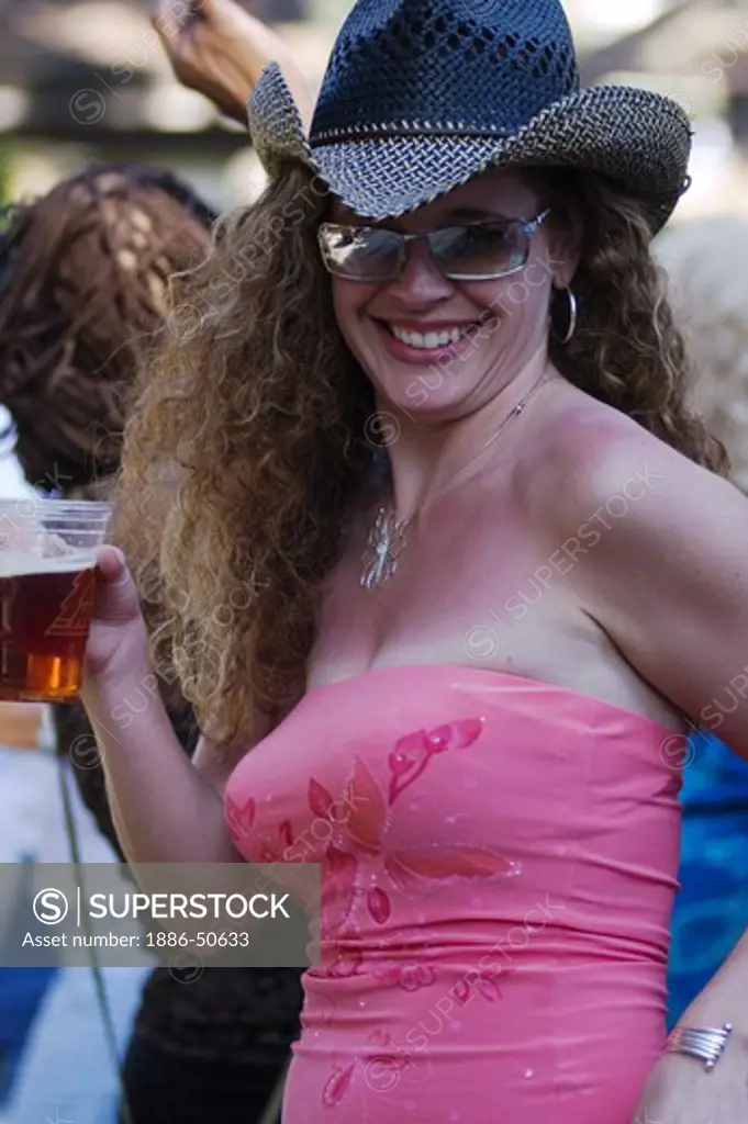 A sexy woman with a glass of beer dances at the MONTEREY BAY BLUES FESTIVAL - MONTEREY, CALIFORNIA