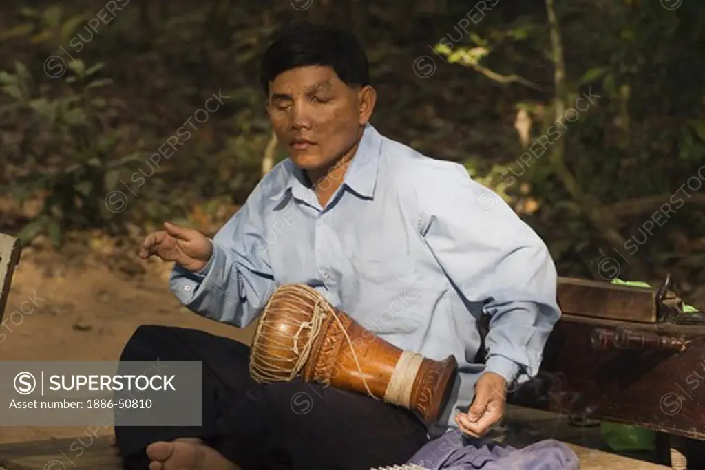 Blind drummer, a victim of a land mind, preforms at the Angkor Wat temple complex - Siem Reap, Cambodia