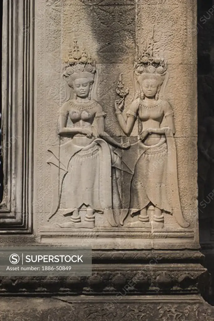 Two stone carved bas relief apsaras (celestial maidens) at Angkor Wat, built in the 11th century by Suryavarman the 2nd,  -  Cambodia
