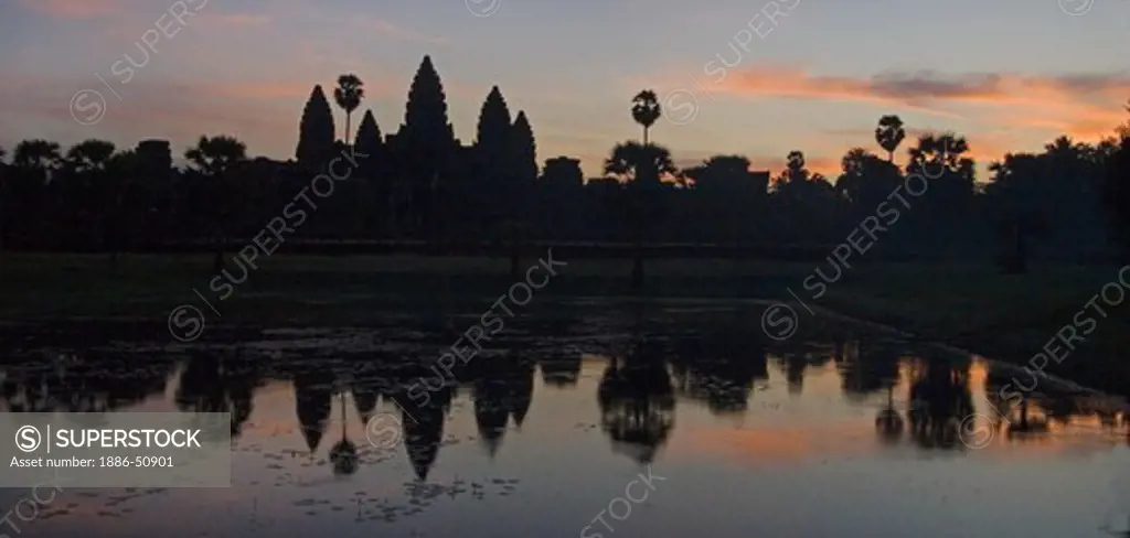 Stone temples representing the five peaks of Mount Meru reflected in a pond at an Angkor Wat sunrise, built in the 11th century by Suryavarman the 2nd  -  Cambodia