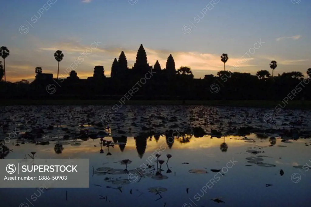 Stone temples representing the five peaks of Mount Meru reflected in a pond at an Angkor Wat sunrise, built in the 11th century by Suryavarman the 2nd  -  Cambodia