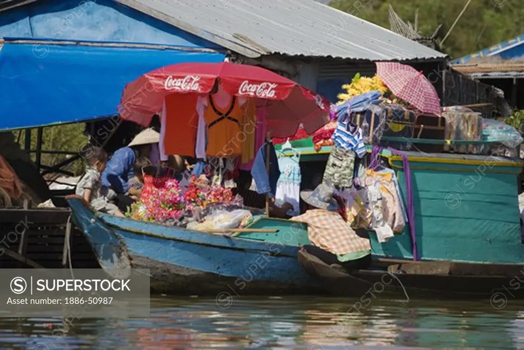 Merchant boat with Coca cola umbrella in the Vietnamese floating village of Chong Kneas on lake Tonle Sap - Siem Reap, Cambodia