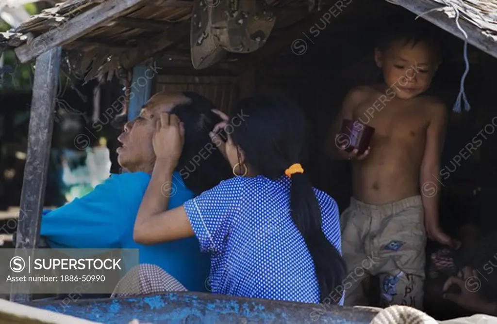 Family grooming on a houseboat in the Vietnamese floating village of Chong Kneas on lake Tonle Sap - Siem Reap, Cambodia