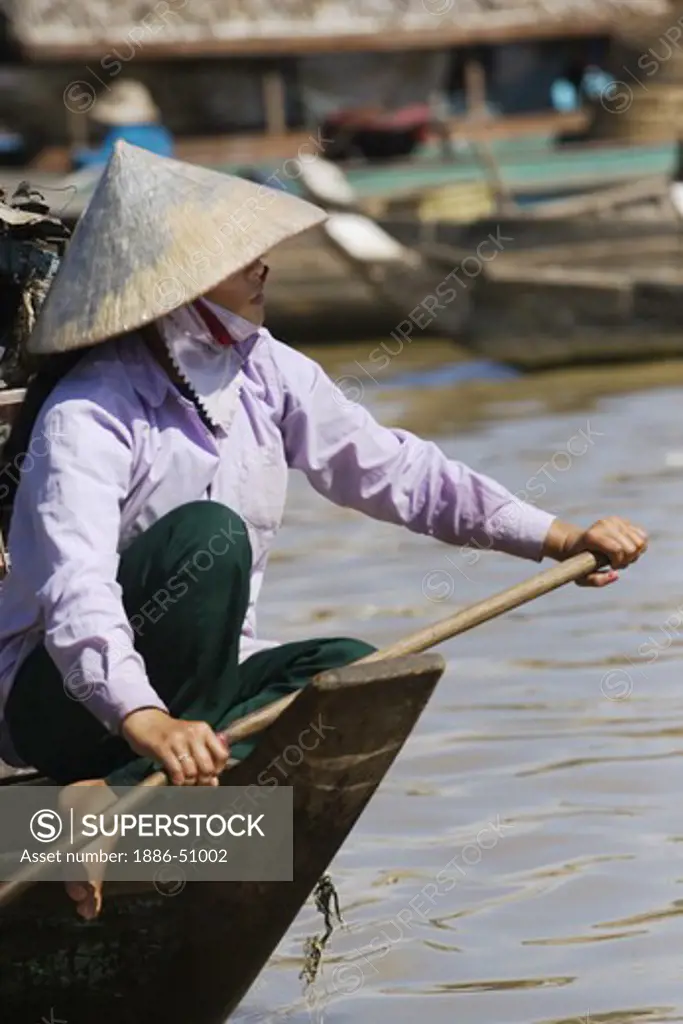 A woman polls her boat in the Vietnamese floating village of Chong Kneas on lake Tonle Sap - Siem Reap, Cambodia