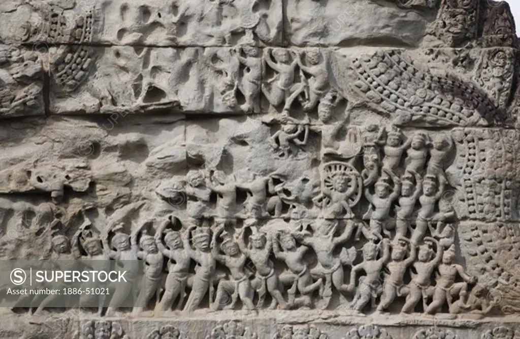 Stone carved bas relief of Hindu mythological battle at the ancient ruins of  Angkor Wat, built in the 11th century by Suryavarman the 2nd,  -  Cambodia