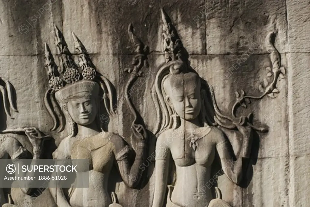 Stone carved bas relief of two Apsaras (celestial maidens) at Angkor Wat, built in the 11th century by Suryavarman the 2nd,  -  Cambodia