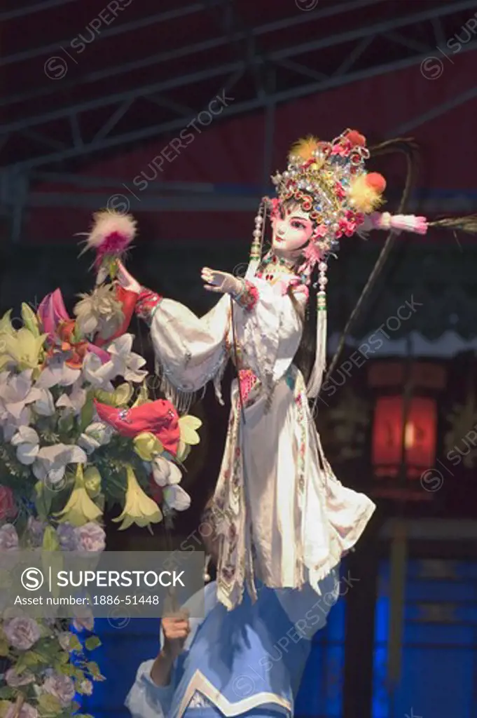 Female puppet picks a flower in a traditional Chinese Puppet Show drama - Chengdu, China in Sichuan Province
