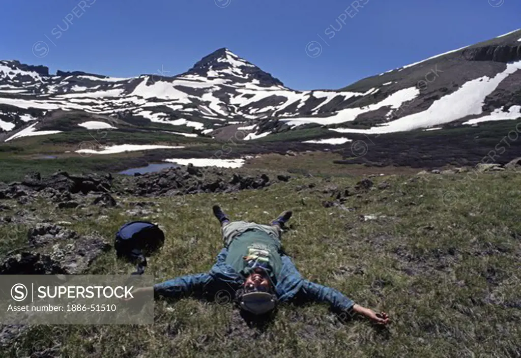 Hiker rests below the RIO GRANDE PYRAMID which reaches a height of 13,821 - COLORADO ROCKIES