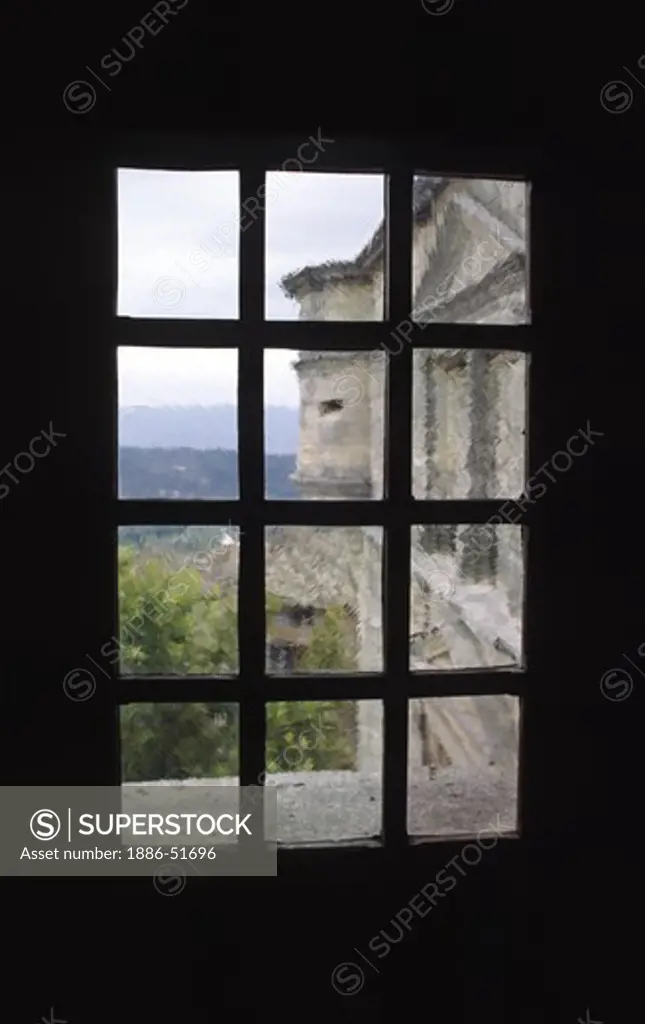 A RENAISSANCE CHATEAU as seen through an old glass window in the rural village of GORDES  - PROVENCE, FRANCE