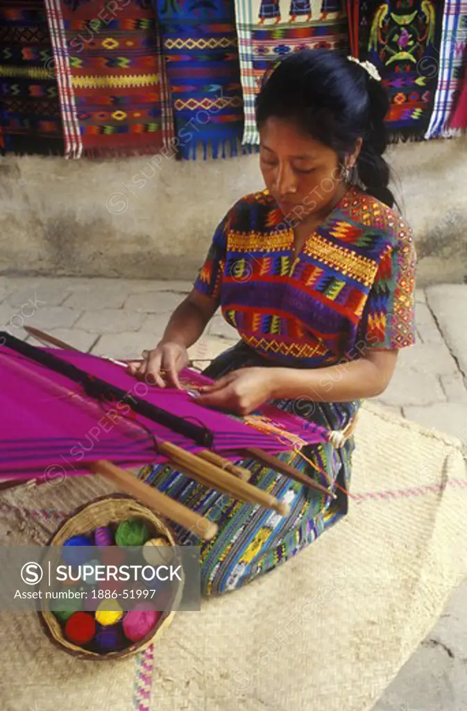INDIGENOUS WOMAN with traditional BACKSTRAP LOOM weaving a HUIPIL, a traditional bracade cloth - GUATEMALA