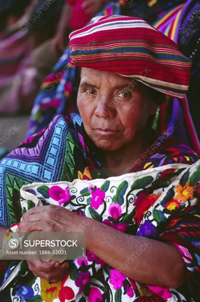 MAYAN WOMAN wearing traditional brocade HUIPILS in MARKETPLACE - CHICHICASTENANGO, GAUTAMALA