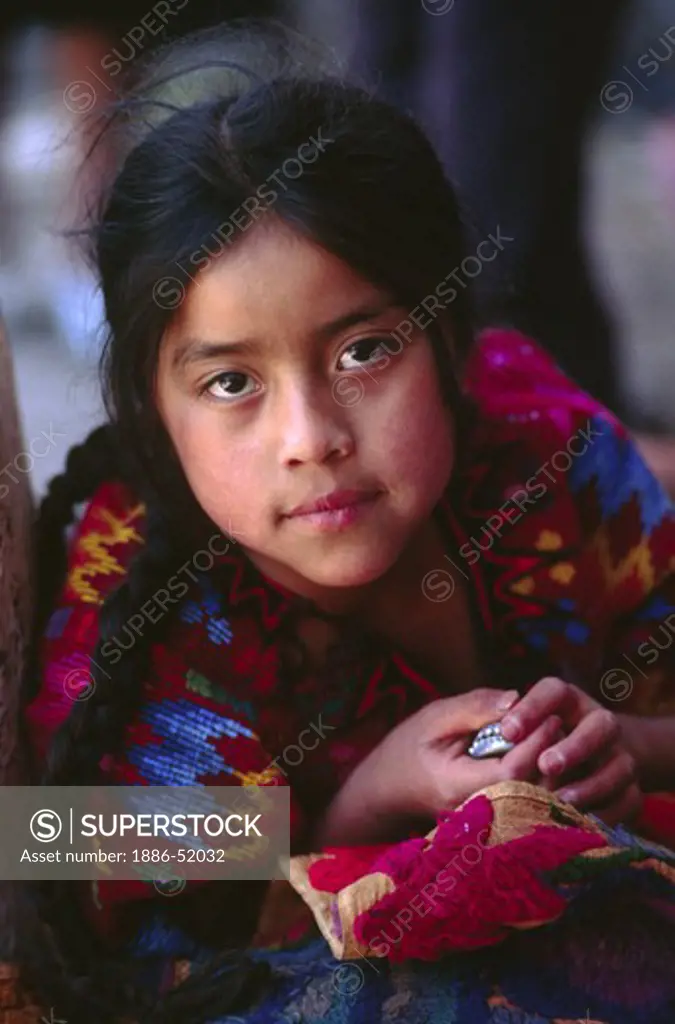 GUATAMALAN GIRL wearing traditional brocade HUIPIL in MARKETPLACE - CHICHICASTENANGO, GAUTAMALA