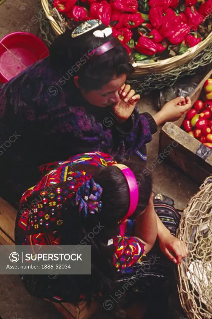 GUATAMALAN GIRLS selling TOMATOES and PEPPERS in the MARKETPLACE - CHICHICASTENANGO, GAUTAMALA