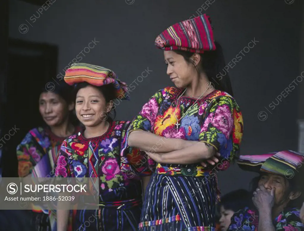 GUATAMALAN WOMEN of MAYA descent wearing traditonal brocade HUIPILS - CHICHICASTENANGO, GAUTAMALA