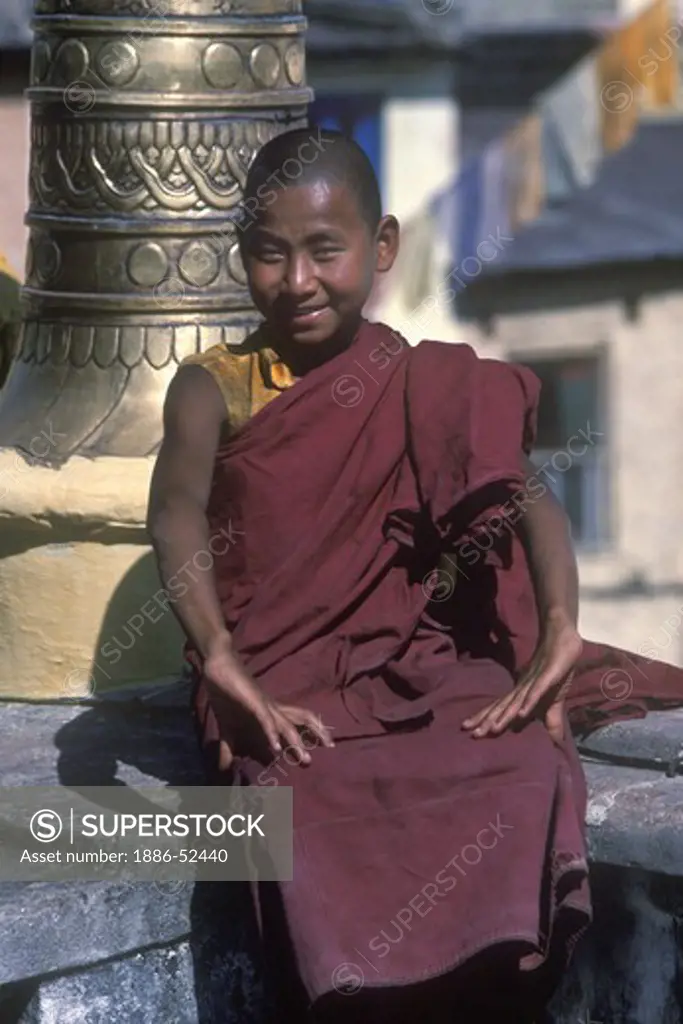 A young Buddhist monk at SWAYAMBUNATH STUPA TEMPLE COMPLEX - KATHAMANDU, NEPAL