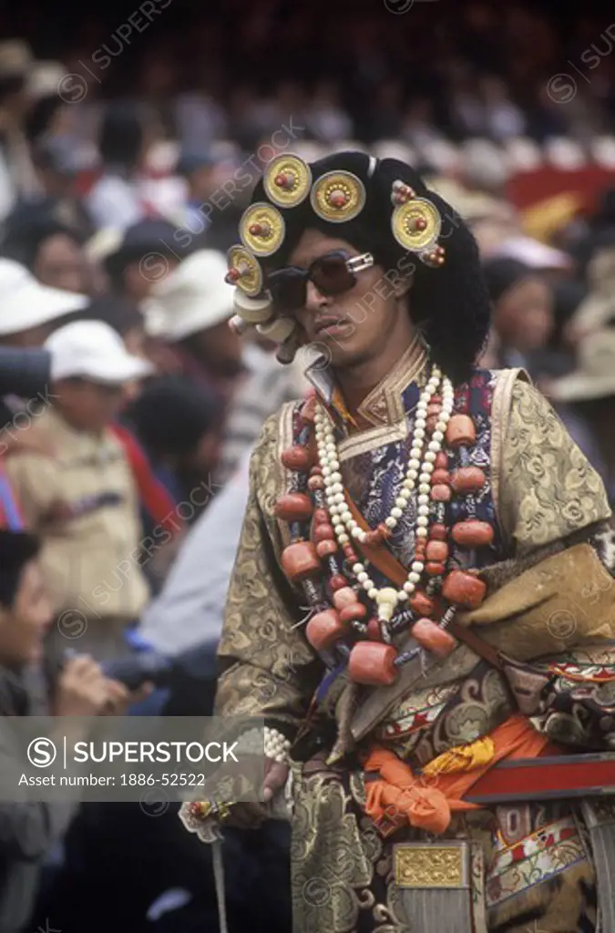 Male Khampa wears tiger skin, coral, zee stones & gold gau boxes at the Litang Horse Festival - Sichuan Province, China, (Tibet)