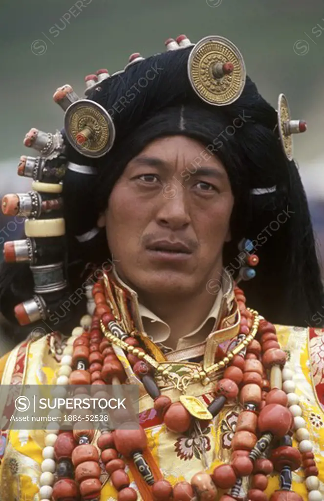 Male Khampa wears coral, zee stones & gold hair ornaments at the Litang Horse Festival - Sichuan Province, China, (Tibet)