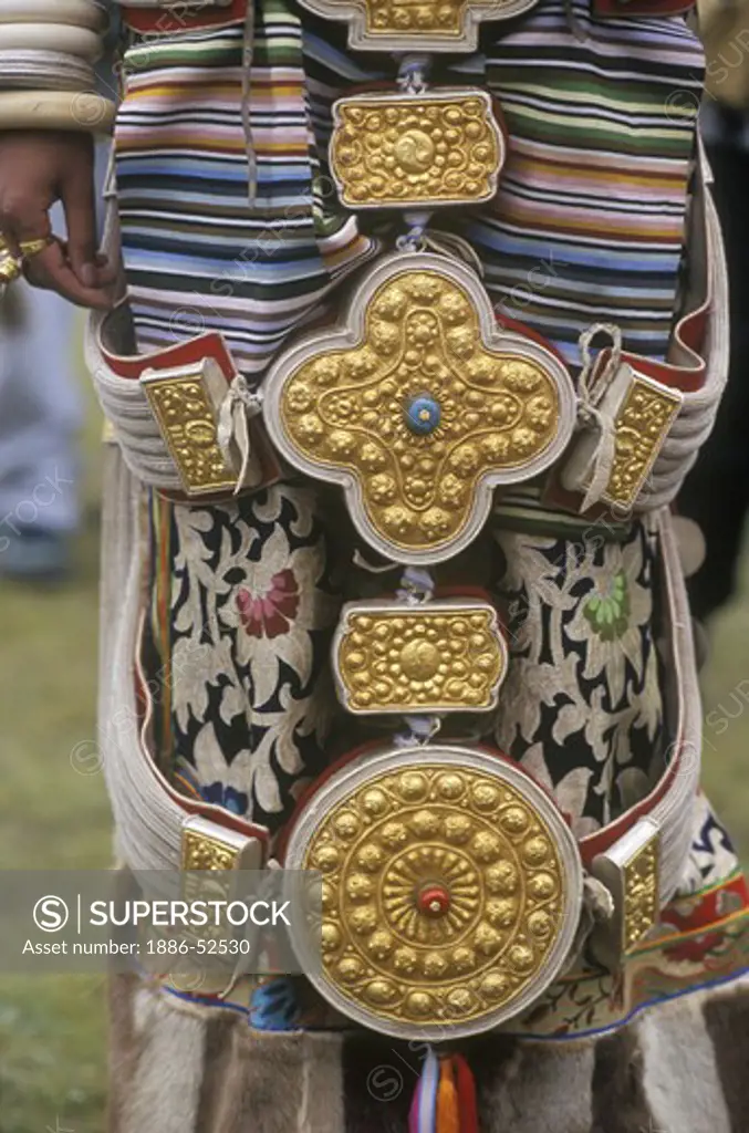 Detail of traditional female Khampa wearing gold & silver gau boxes at the Litang Horse Festival - Sichuan Province, China