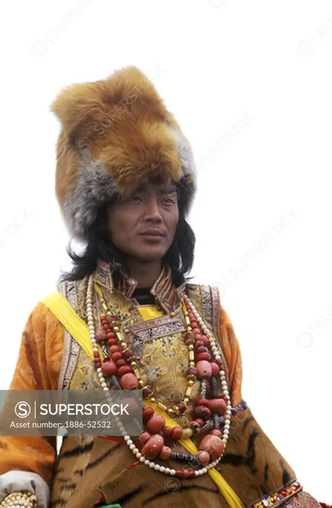 Male Khampa wears coral, zee stones, fox fur hat & tiger skin at the Litang Horse Festival - Sichuan Province, China, (Tibet)