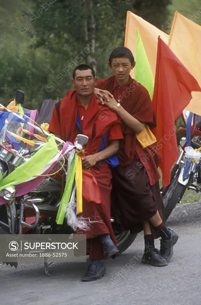 Buddhist monks with motorcycle  decorated with  katoks and prayer flags - Kham, (E. Tibet), Sichuan Province, China