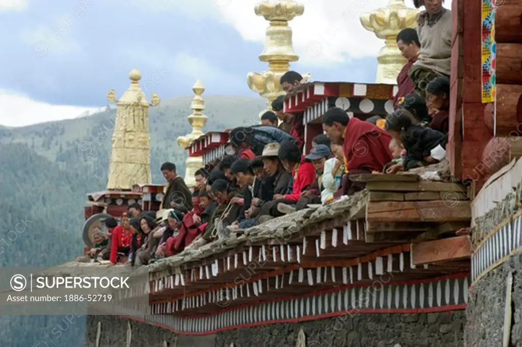 Khampas watch the Monlam Chenmo masked dances from the roof, Katok Dorjeden Monastery - Kham, (Tibet), Sichuan, China