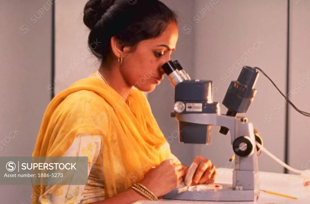 Electronics; Indian woman looking into microscope