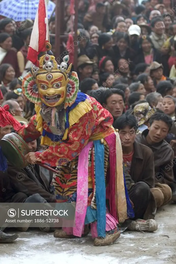 Masked dancer sits on crowd as part of the preformance at the Monlam Chenmo, Katok Monastery - Kham, (Tibet), Sichuan, China