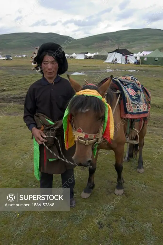 Khampa man & Tibetan pony wait for a chance to race at the Litang Horse Festival - Sichuan Province, China, (Eastern, Tibet)