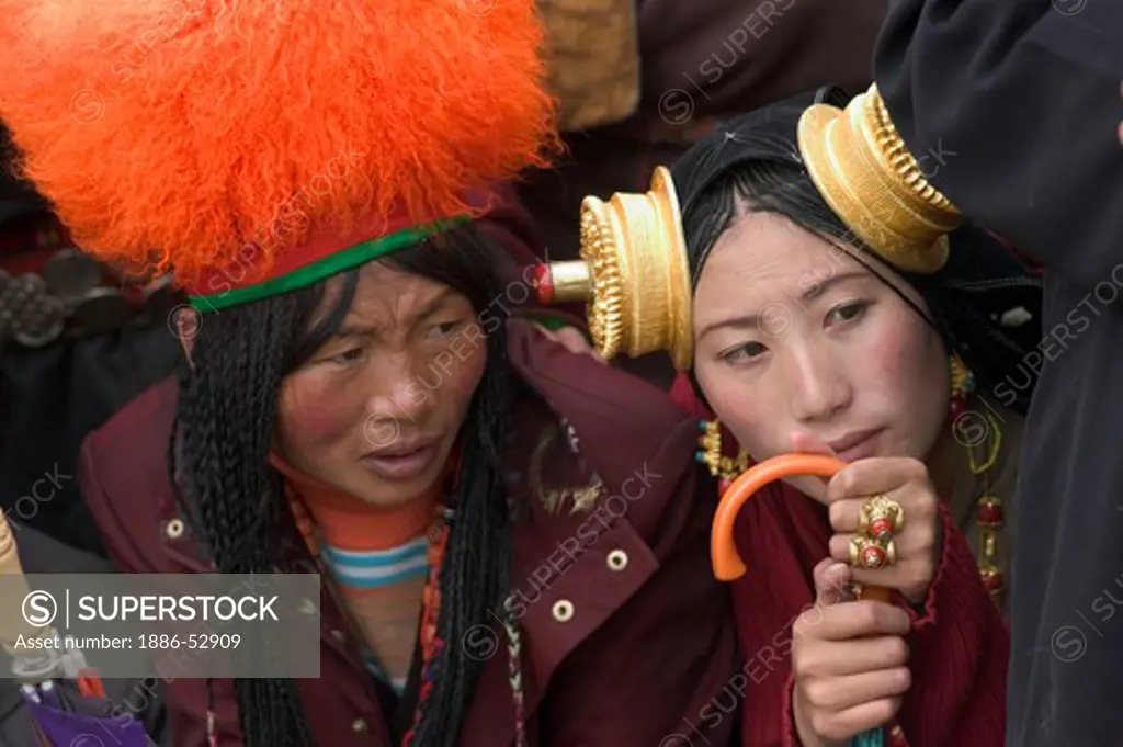 Detail of traditional female Khampas Orange Fuzzy Hat, wearing gold & coral hair peices at the Litang Horse Festival - Sichuan Province, China (Tibet)