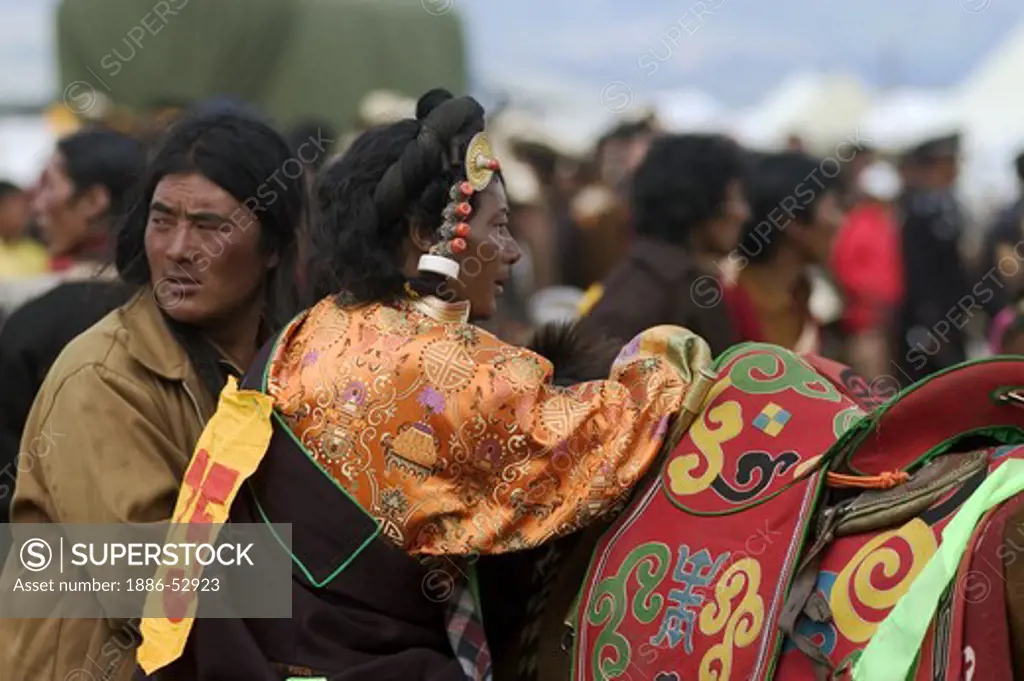 A Khampa prepares to ride at the Litang Horse Festival in Kham - Sichuan Province, China, (Tibet)