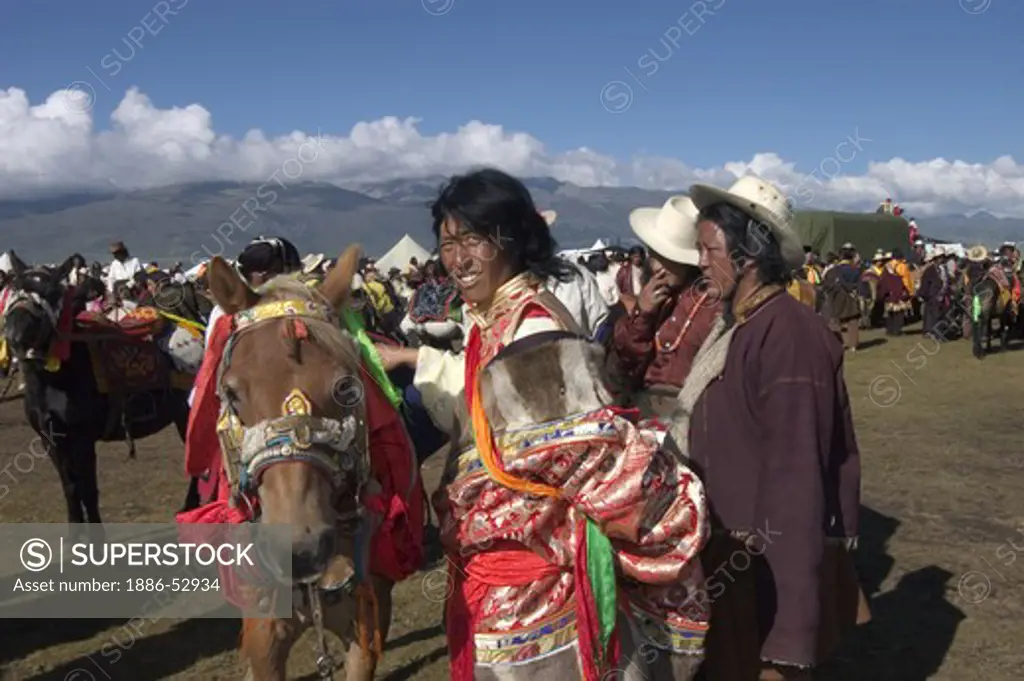 Khampa man & Tibetan pony wait for a chance to race at the Litang Horse Festival - Kham, Sichuan Province, China, (Tibet)