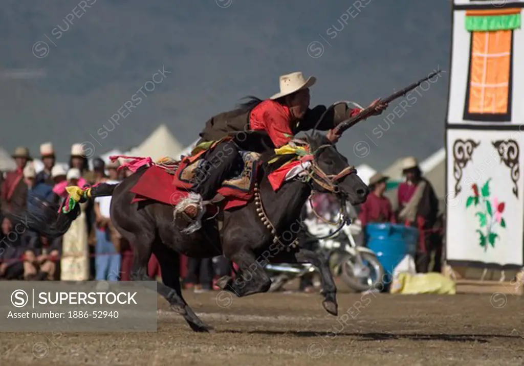 Khampas compete in rifle shooting contest on horseback at the Litang Horse Festival - Kham, Sichuan Province, China, (Tibet)