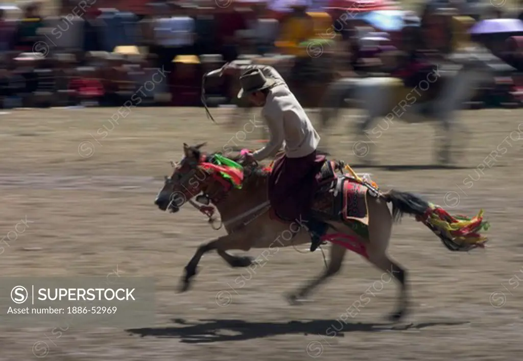 Khampas entertain the crowd in a rowdy horse race at the Litang Horse Festival - Kham, Sichuan Province, China, (Tibet)