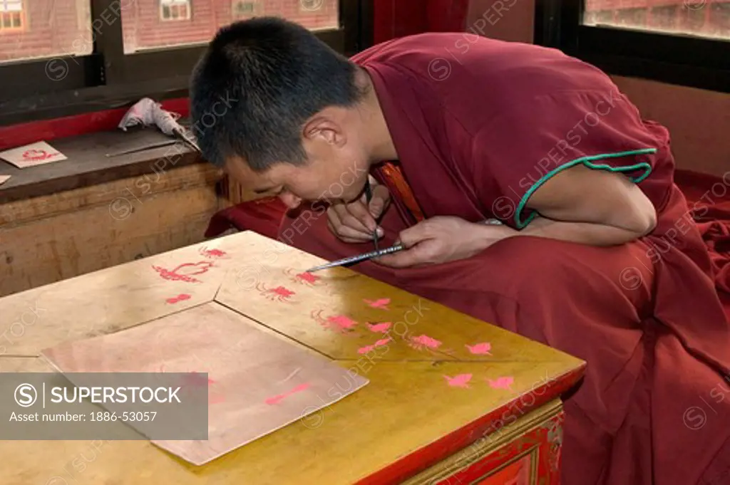 Buddhist monk practices sand mandala painting in Dhokham Garther Monastery - Kham, Sichuan Province, China, (Tibet)