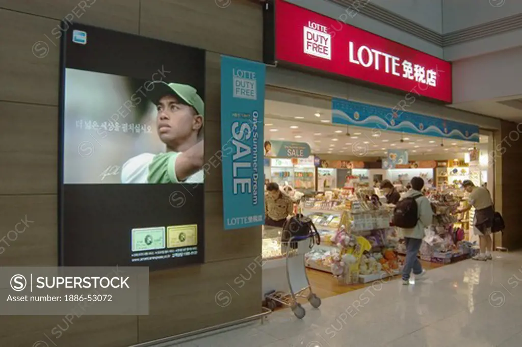 Airport terminal Lotte duty free store with Tiger Woods advertisement for American Express - Seoul, South Korea