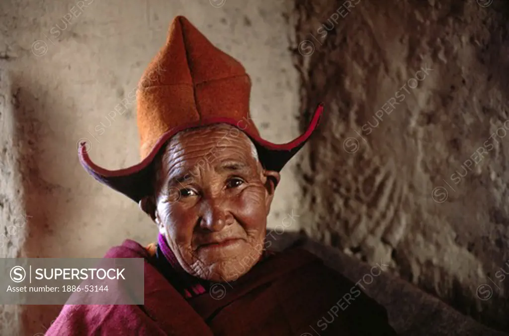 Beautiful LADAKHI NUN, wearing hat, with a SMILING and wrinkled face, TIKSE Monastery - LADAKH, INDIA