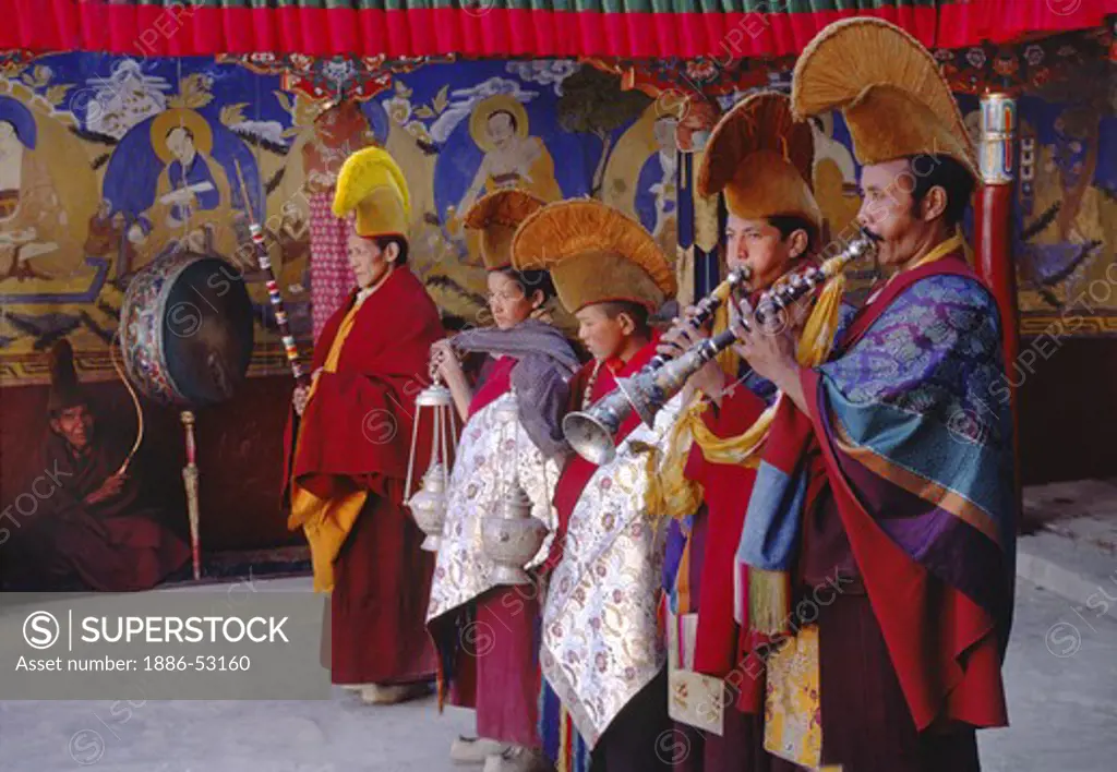 BUDDHIST yellow hat MONKS play TRUMPETS to begin the dances, TIKSE Monastery Masked Dances - LADAKH, INDIA