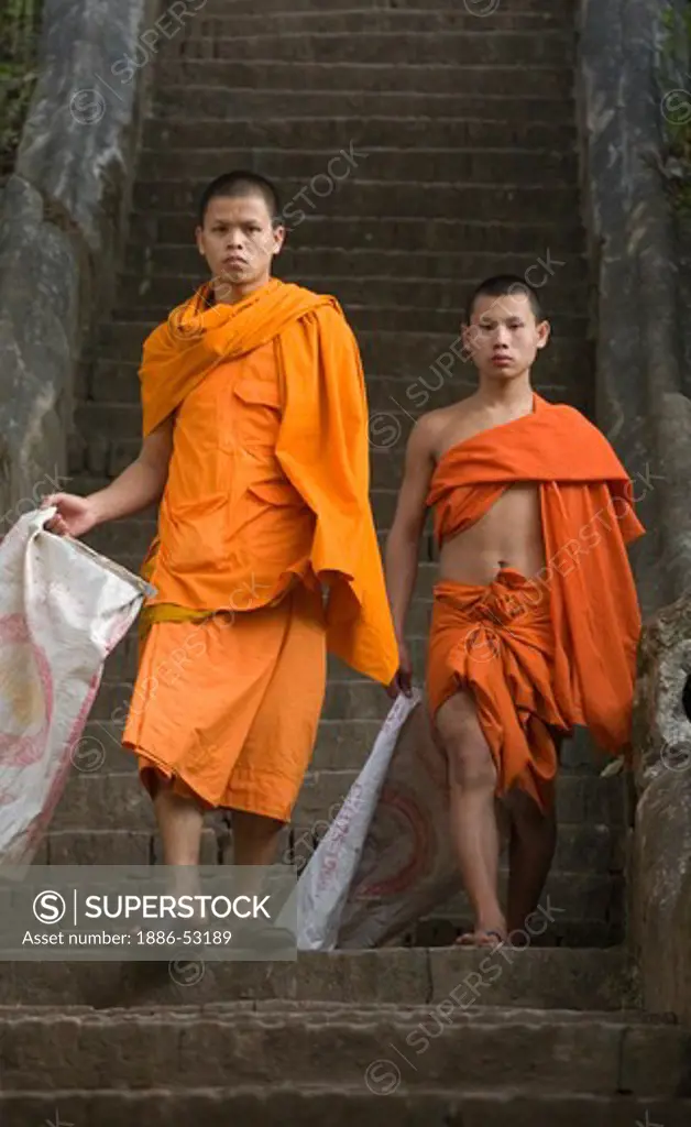 Monks on stairway near Wat Pa Huak in the former French Provincial town of LUANG PROBANG - LAOS