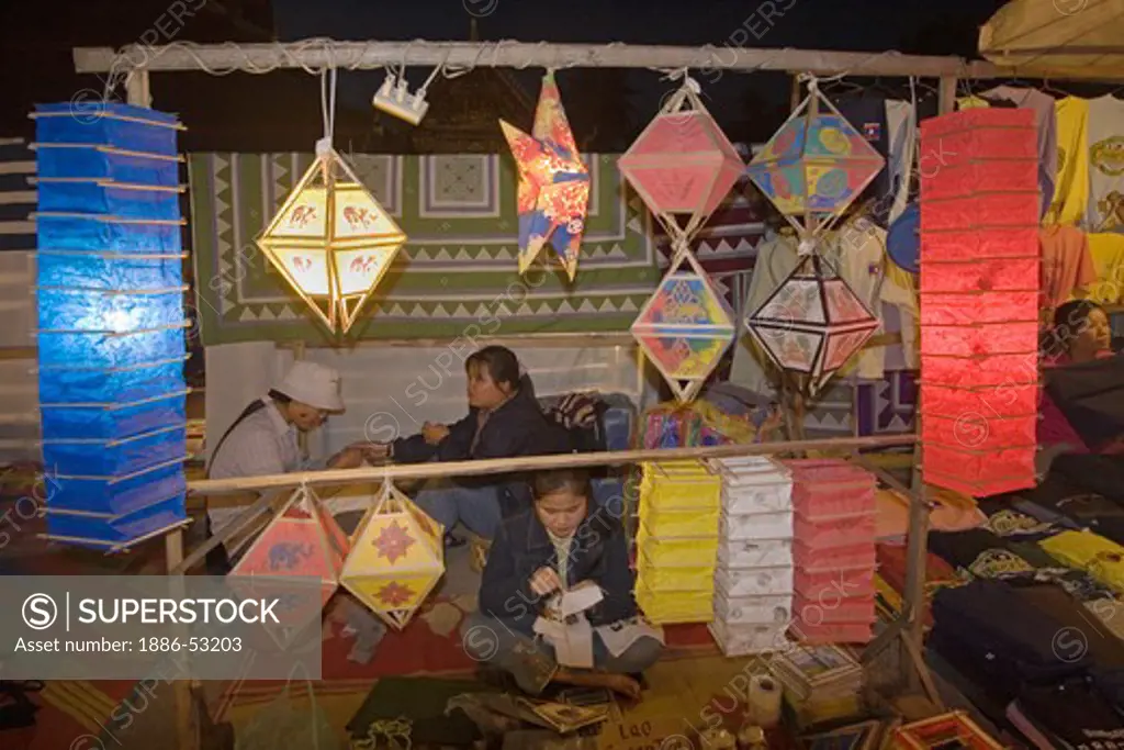 Laotian women sell paper lantern at the famous Night Market in the French Provincial town of LUANG PROBANG - LAOS