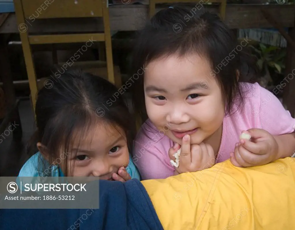 Young Laotian girls smile in LUANG PROBANG which was once a French Provincial town - LAOS
