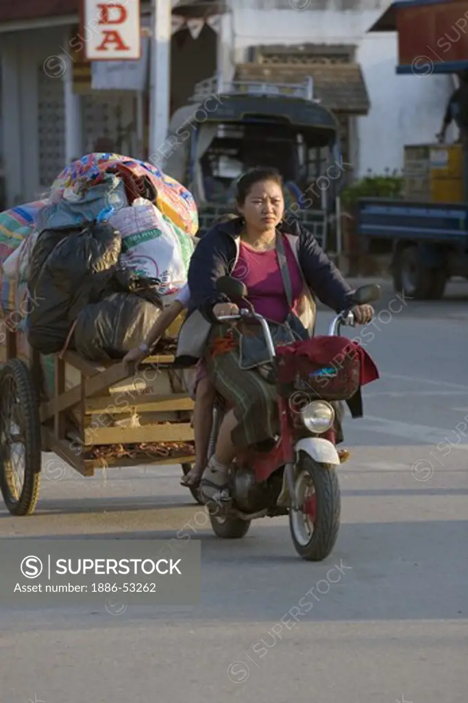 A two wheeled motorcycle are use for transporting goods - LUANG PROBANG, LAOS