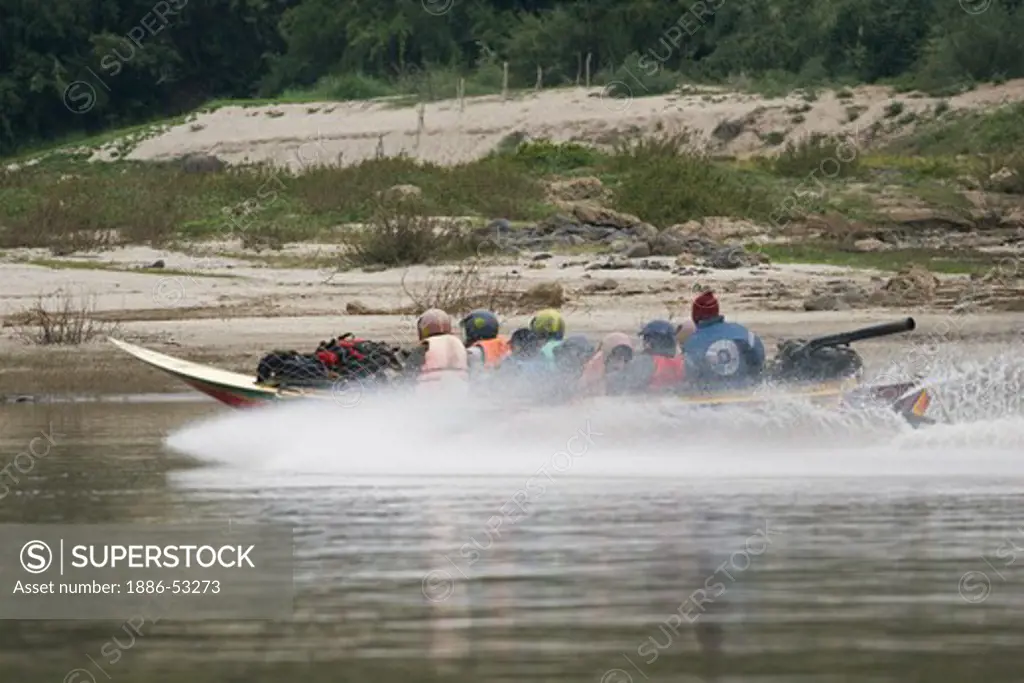 Tourist head up rive in a speed boat which is fast, noisy and thrilling on the Mekong River above LUANG PROBANG - LAOS