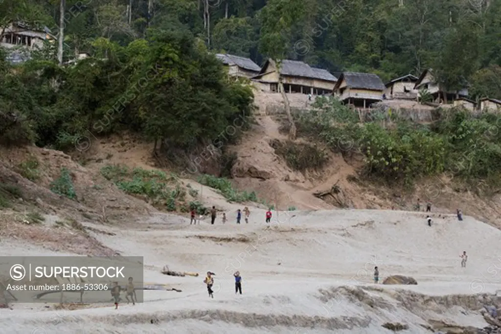 Laotian children play on the sandy banks of the Mekong River in a traditional Laotian village above LUANG PROBANG - LAOS