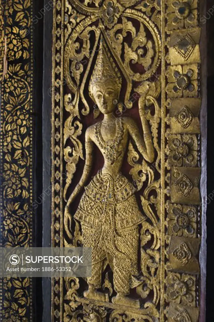 Gold plated Deity on a door inside the Buddhist Temple Wat Xieng Thong, built by King Setthatthirat in 1560 - LUANG PROBANG, LAOS