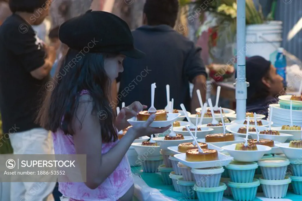 A young Mexican girl sells FLAN during the DEAD OF THE DEAD - SAN MIGUEL DE ALLENDE, MEXICO