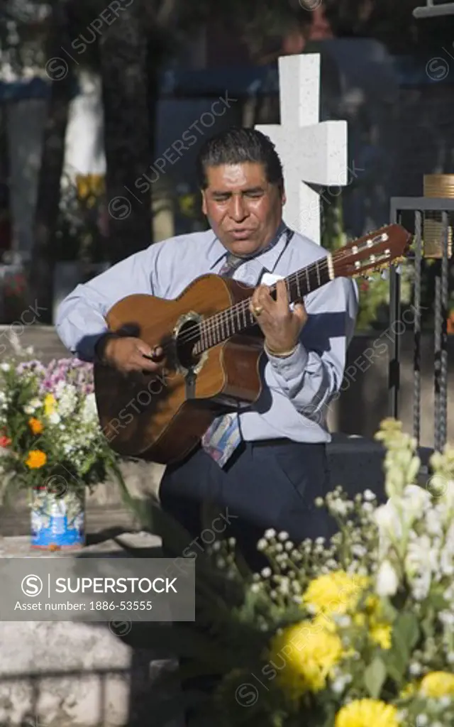 A GUITARIST plays for the dead at the local cemetery during the DEAD OF THE DEAD - SAN MIGUEL DE ALLENDE, MEXICO