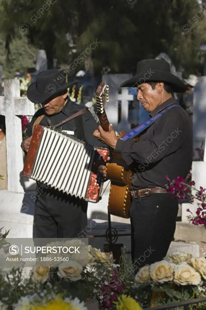 A GUITARIST & ACCORDIONIST plays for the dead at the local cemetery during the DEAD OF THE DEAD - SAN MIGUEL DE ALLENDE, MEXICO