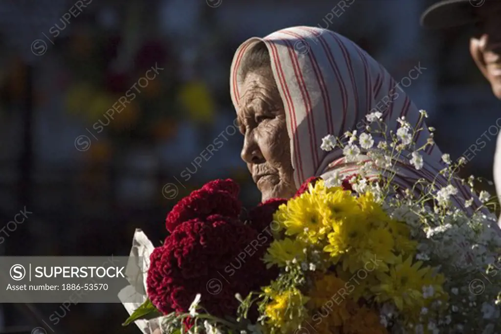 A MEXICAN grandmother brings flowers to the cemetery during the DEAD OF THE DEAD - SAN MIGUEL DE ALLENDE, MEXICO